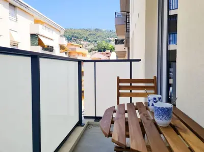 a wooden bench sitting on top of a balcony at Magnifique Appartement - Parking privé - Nice in Nice
