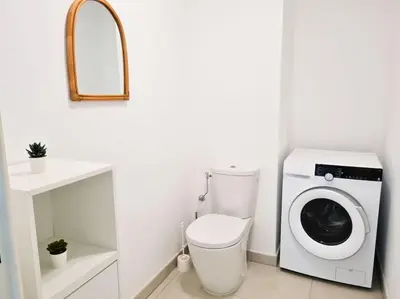 a bathroom with a washing machine and a toilet at Magnifique Appartement - Parking privé - Nice in Nice