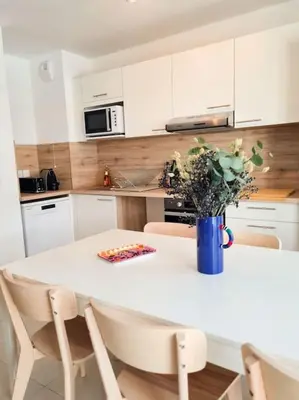 a kitchen with a table with a vase of flowers on it at Magnifique Appartement - Parking privé - Nice in Nice
