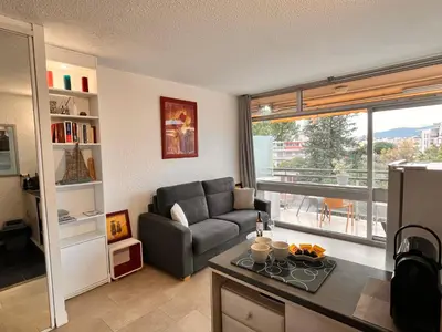 a living room with a couch and a chair and a window at Heliotel Marine Studio 30m2 très lumineux avec terrasse 17m2 au 3eme étage in Saint-Laurent-du-Var