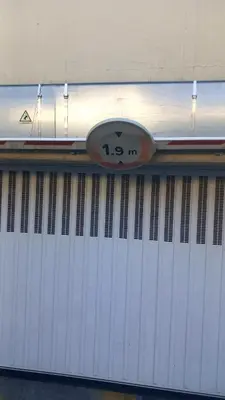 a clock on top of a white garage door at Heliotel Marine Studio 30m2 très lumineux avec terrasse 17m2 au 3eme étage in Saint-Laurent-du-Var