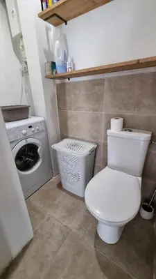 a bathroom with a toilet and a washing machine at T3 au calme à deux pas de la mer in Nice