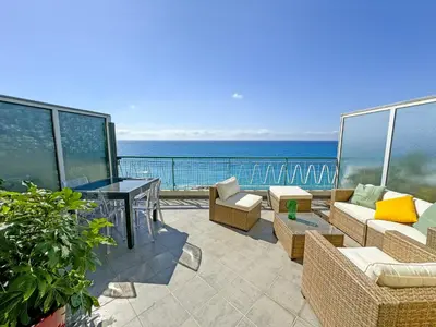 a patio with a view of the ocean on a balcony at Breathtaking Rooftop Experience on Promenade in Nice