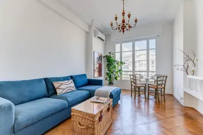 a living room with a blue couch and a table at Elegant Condo with Balconies in the Heart of Nice in Nice