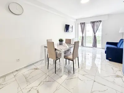 a white dining room with a table and chairs at New Big Flat 8 Pers AC WiFi in Nice