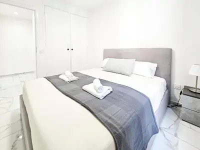 a white bedroom with a bed with towels on it at New Big Flat 8 Pers AC WiFi in Nice