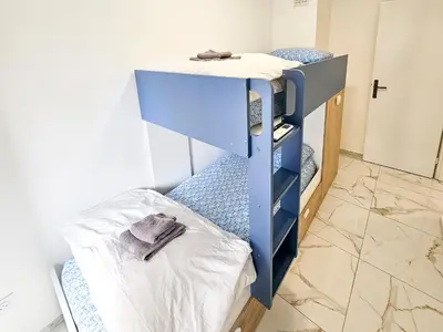 a blue bunk bed in a room with a mattress at New Big Flat 8 Pers AC WiFi in Nice
