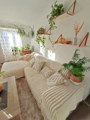 a living room with a large white couch with plants at Chambre à 3 min de la Promenade des Anglais à pieds 200m in Nice