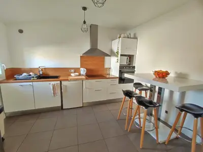 a kitchen with white cabinets and a counter and stools at Chambre à 3 min de la Promenade des Anglais à pieds 200m in Nice