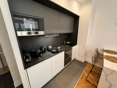 a kitchen with white cabinets and a stove top oven at Luxury Central Condo with Private Terrace in Nice in Nice