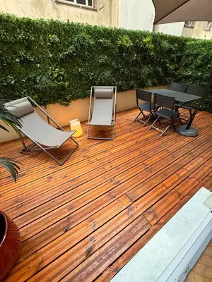 a wooden deck with a table and chairs and an umbrella at Luxury Central Condo with Private Terrace in Nice in Nice
