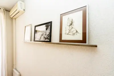 a shelf with three pictures on a wall at Palais Magnan 4 Pers WiFi AC in Nice