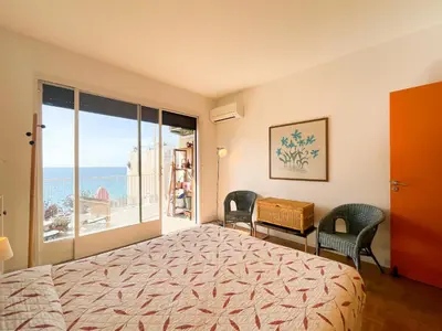 a bedroom with a bed and a view of the ocean at Paradise 4 Pers Vista Mare Wifi AC in Nice