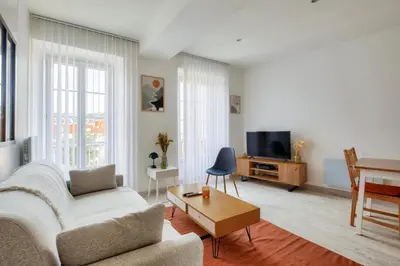 a living room with a couch and a table and a tv at Lovely 1 BR Flat in the heart of Nice in Nice