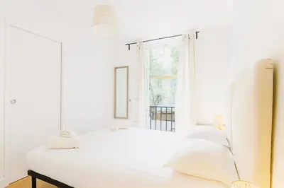 a white bedroom with a bed and a window at Cassini 2 Pers Hyper Center WiFi in Nice