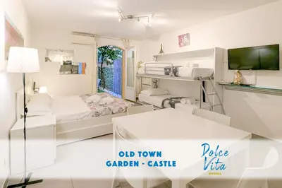 a white room with a bed and a table at Chateau 4 Pers Vecchia Nizza AC WiFi in Nice