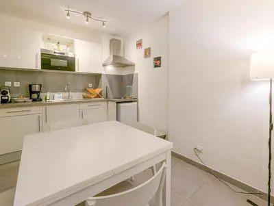 a white kitchen with a white table and chairs at Chateau 4 Pers Vecchia Nizza AC WiFi in Nice