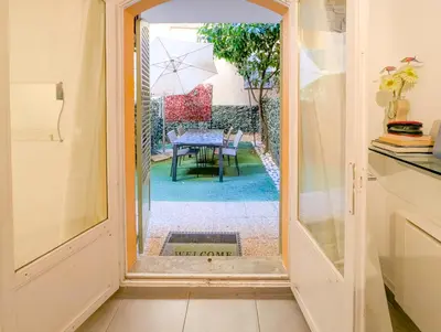 an open door to a patio with a table and umbrella at Chateau 4 Pers Vecchia Nizza AC WiFi in Nice