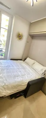 a bedroom with a large bed and a window at Studio Nice Plage Luxe in Nice