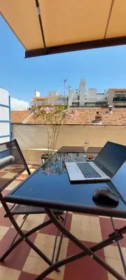 a laptop computer sitting on a table on a patio at Studio with large terrace sea view 4th floor in Nice