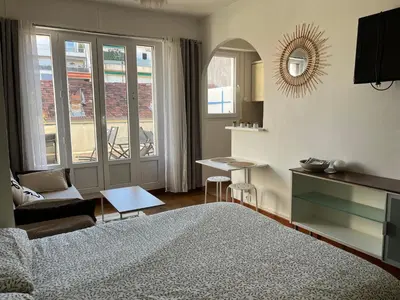a bedroom with a bed and a table and a mirror at Studio with large terrace sea view 4th floor in Nice