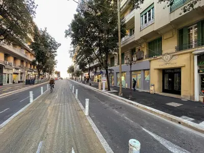 a person riding a bike down a city street at Comte De Nice 4Pers Parking Available WiFi AC in Nice