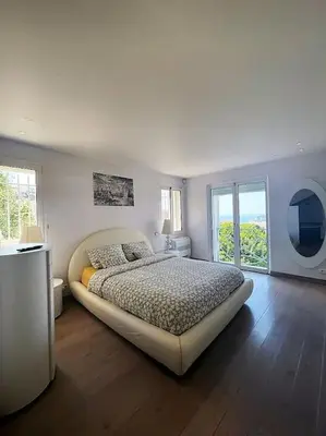 a bedroom with a large bed and two windows at MONT BORON - NICE - Splendide villa d'architecte vue panoramique in Nice