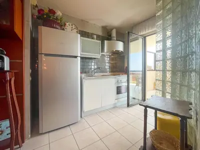 a kitchen with a white refrigerator and a table at La Dolce Vita 6 Pers Parcheggio Terrazza in Nice