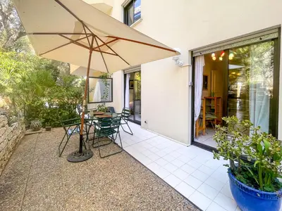 a patio with an umbrella and a table and chairs at La Dolce Vita 6 Pers Parcheggio Terrazza in Nice