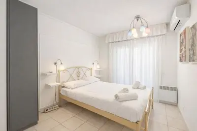 a white bedroom with a bed and a window at La Dolce Vita 6 Pers Parcheggio Terrazza in Nice