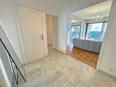 a living room with a blue couch and a window at Cosy Cariatides Condo Promenade in Nice