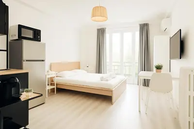 a white bedroom with a bed and a desk at Stella Monte 2 AC WiFi 2 Pers in Nice