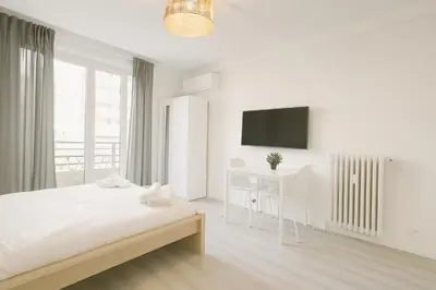 a white bedroom with a bed and a desk at Stella Monte 2 AC WiFi 2 Pers in Nice