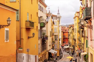 a street in an old town with yellow buildings at Stella Monte 2 AC WiFi 2 Pers in Nice
