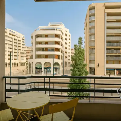 a balcony with two tables and chairs and buildings at Stella Monte 2 AC WiFi 2 Pers in Nice