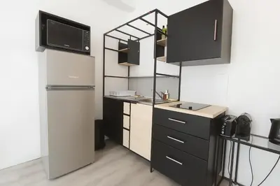 a kitchen with black cabinets and a refrigerator at Stella Monte 3 AC WiFi 2 Pers in Nice