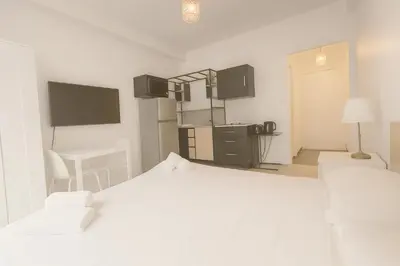 a white room with two beds and a kitchen at Stella Monte 3 AC WiFi 2 Pers in Nice