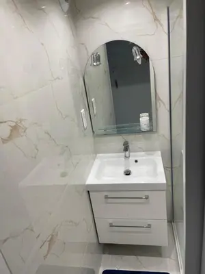 a white bathroom with a sink and a mirror at Studio Lumineux à 2min de là plage in Nice