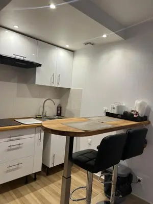 a kitchen with a wooden table and two chairs at Studio Lumineux à 2min de là plage in Nice