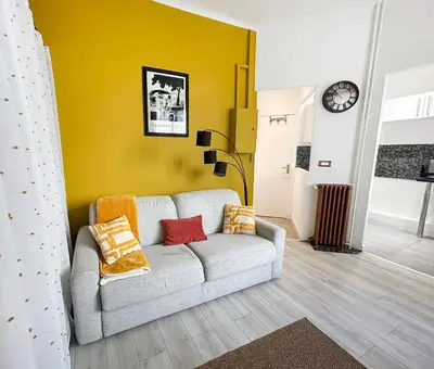 a living room with a couch and a yellow wall at Charmant studio au coeur de Nice in Nice