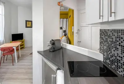 a kitchen with a counter and a table in a room at Charmant studio au coeur de Nice in Nice