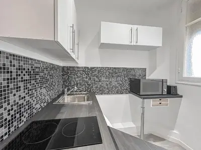 a white kitchen with a sink and a microwave at Charmant studio au coeur de Nice in Nice