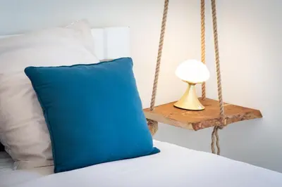 a blue pillow sitting on a bed next to a table at Bel appartement vue mer proche de la promenade des anglais in Nice