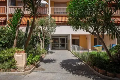 a walkway in front of a building with trees at Bel appartement vue mer proche de la promenade des anglais in Nice