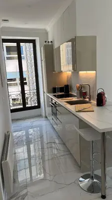 a white kitchen with a counter and a window at Le Félix in Nice