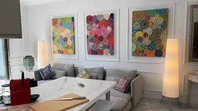 a living room with three paintings on the wall at Le Félix in Nice