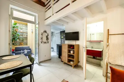 a living room with a table and a dining room at Jolie duplex avec patio in Nice