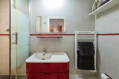 a bathroom with a red sink and a mirror at Jolie duplex avec patio in Nice