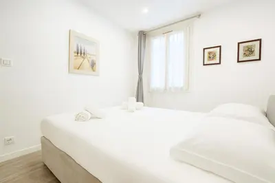 a white bedroom with a large bed and a window at Massena 4 Pers Super Centrale WiFi AC in Nice