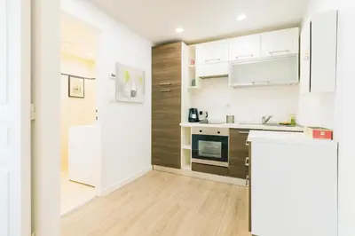 a kitchen with white cabinets and a refrigerator at Massena 4 Pers Super Centrale WiFi AC in Nice